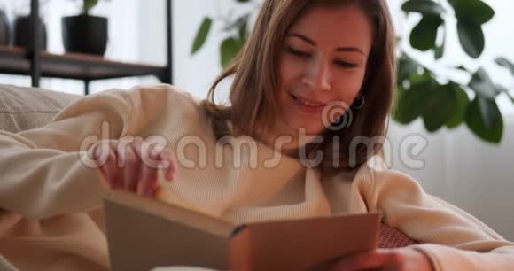 在家沙发上看书的女人视频的预览图