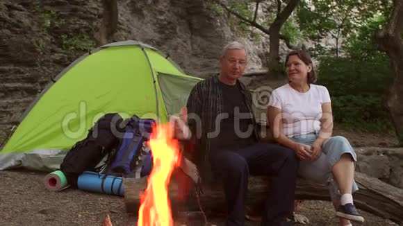 一对夫妇坐在火旁用毯子盖着视频的预览图