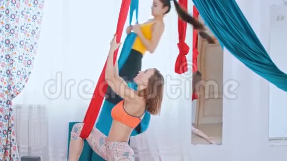 空中瑜伽两名运动女性在光明工作室接受训练视频的预览图