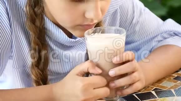 快乐的孩子迷人的小女孩在街头咖啡馆喝可可的肖像微笑着快关门4k视频的预览图