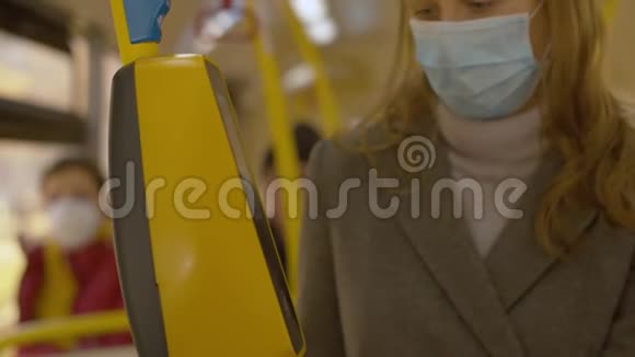 戴口罩和手套的女人在公车上付钱视频的预览图