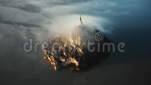 无人机在令人惊叹的圣米歇尔岛城堡城堡周围高高飞起布满了巨大的日出雾云视频的预览图