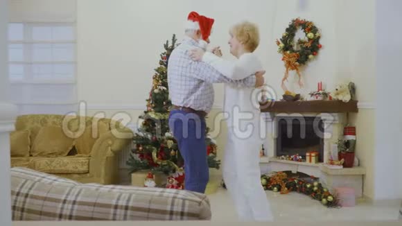 快乐成熟的女人和丈夫在家附近的圣诞树跳舞视频的预览图