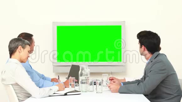 商业团队看着白色屏幕和交谈视频的预览图