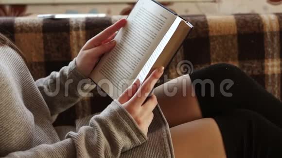 这本书在一个女孩的膝上视频的预览图