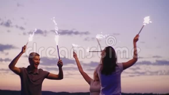 朋友们在烟花中玩得很开心日落之后海滩派对慢速视频视频的预览图