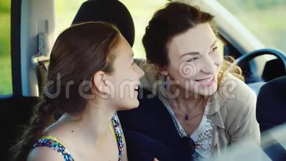 母亲和女儿与青少年之间的信任和友好交流坐在车里视频的预览图