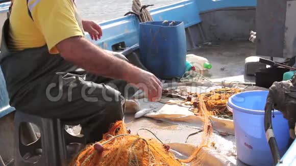 渔夫在他的小船上把网里的鱼捞空了视频的预览图