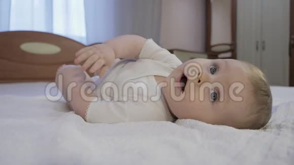 可爱的宝宝蓝眼睛躺在床上视频的预览图