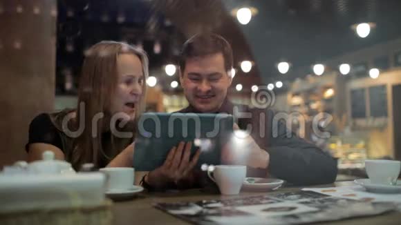 在咖啡馆分享他们的网上相册视频的预览图