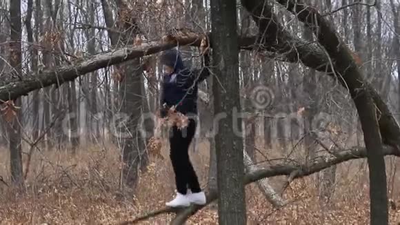在树林里骑在破树上的男孩视频的预览图
