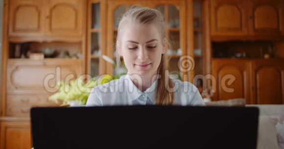微笑的女人在笔记本电脑上工作视频的预览图