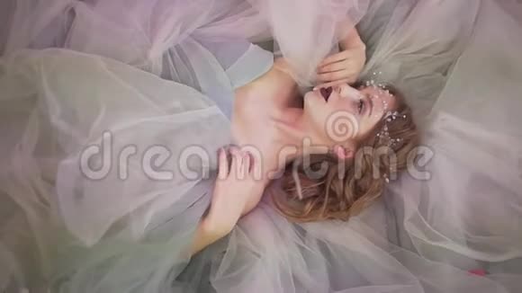 美丽的年轻迷人的职业女性模特戴着华丽的仙尾公主蕾丝连衣裙躺在地板上视频的预览图