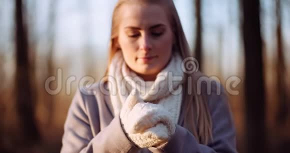 女人在秋天温暖双手视频的预览图