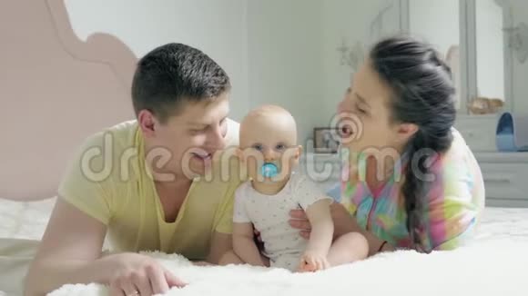 爸爸妈妈在床上亲吻宝宝视频的预览图