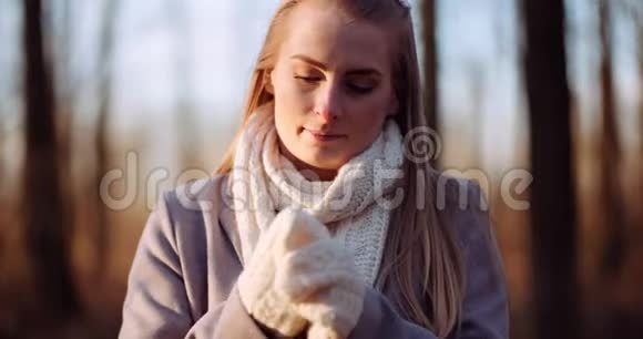 女人在秋天温暖双手视频的预览图