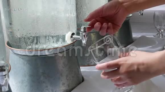 女人从饮水机里拿一杯水的动作视频的预览图