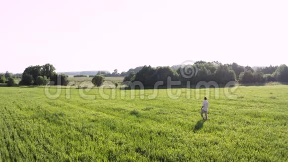 一个人走在绿色的田野上视频的预览图