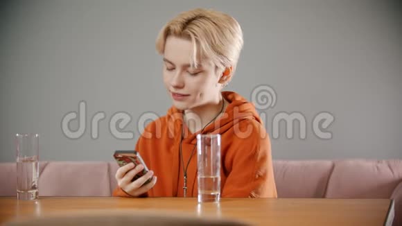 一个女孩正在咖啡馆里浏览电话视频的预览图