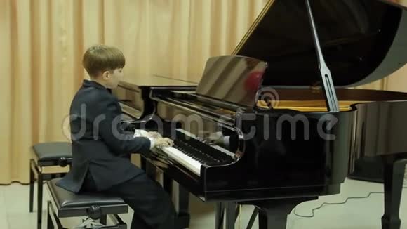 男孩在弹大钢琴视频的预览图