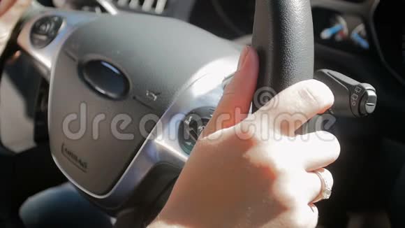 女性驾驶员手握汽车方向盘的慢速镜头视频的预览图