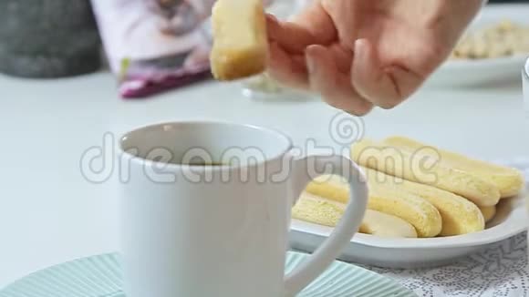 女人的手把女人的手指伸进咖啡杯视频的预览图