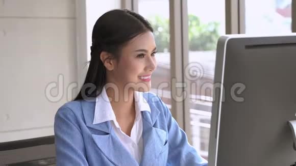 女商人正在使用电脑来协调办公室的业务视频的预览图