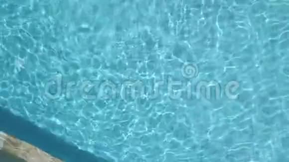 穿着蓝色泳衣的漂亮女孩潜入酒店游泳池在水下游泳视频的预览图