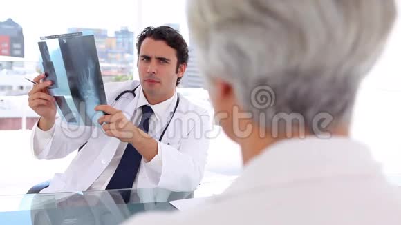 微笑的医生在病人面前拿着X光片视频的预览图