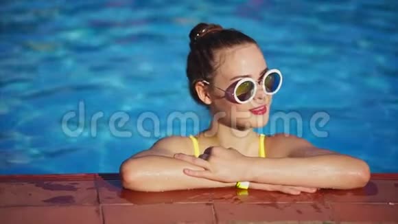 红头发的女人在游泳池里放松她站在游泳池旁边视频的预览图