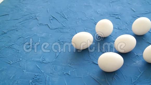 白色的鸡蛋躺在蓝色的桌子上视频的预览图