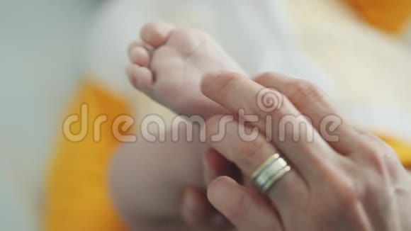 婴儿的脚在母亲的手中小宝宝的脚放在女性心形的手上特写妈妈和她的孩子幸福家庭观视频的预览图