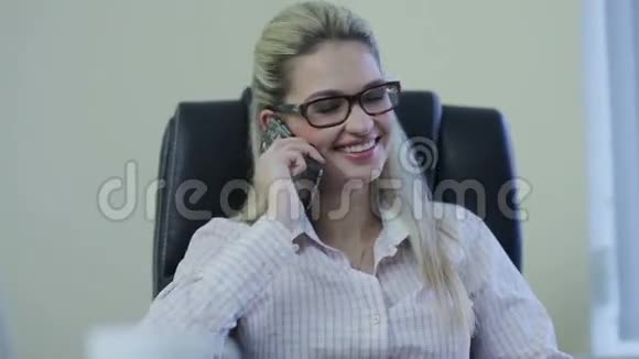 微笑的女商人用手机说话视频的预览图