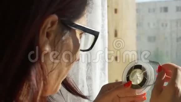 女人看着8毫米卷轴视频的预览图