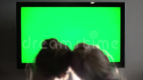 两个年轻的长发金发碧眼看着绿色的电视屏幕直着头视频的预览图