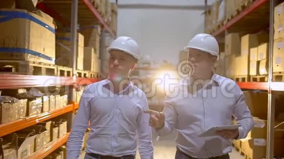 员工男仓库工人安全帽工程师在物流中心工厂施工现场工作两名视频的预览图