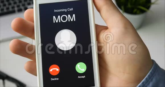 接到妈妈的电话并接受移动通信概念坐在书桌前视频的预览图