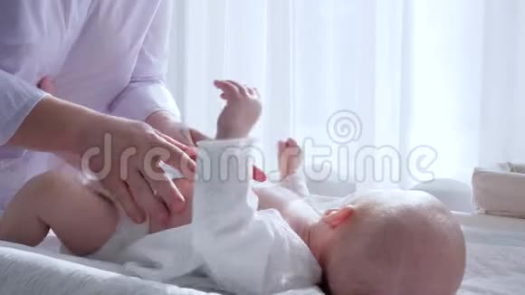 产妇的柔情女人的手在房间里给新生儿做按摩视频的预览图