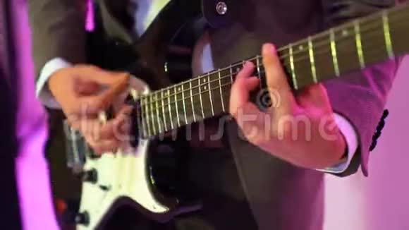 4k吉他手在夜总会舞台上弹声吉他彩灯闪烁视频的预览图