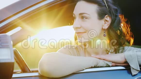 迷人的女人看着车窗外肖像她身后是夕阳的光芒快乐的司机视频的预览图