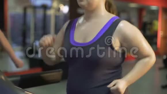 强壮的超重女性努力减肥在跑步机上出汗视频的预览图