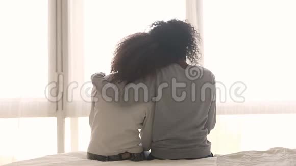 非洲母亲抱着坐在床上的未成年女儿后视镜视频的预览图