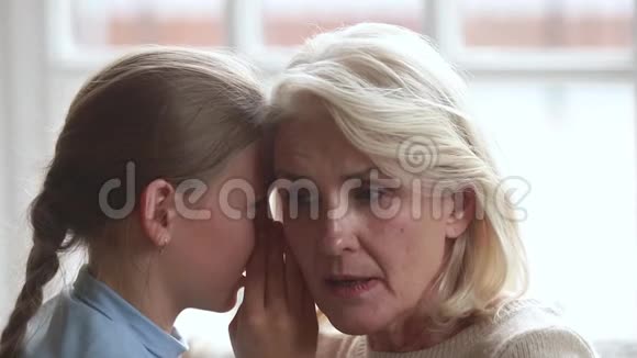 特写镜头小孙女在奶奶耳边低语视频的预览图