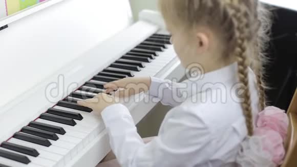 儿童用白色钢琴演奏音乐视频的预览图