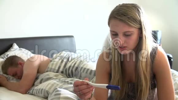 带怀孕测试工具包的卧室里担心的少女视频的预览图