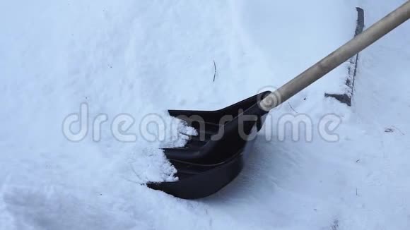用铲子清理雪女人用铲子清理雪中的雪视频的预览图