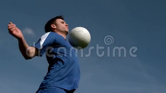 足球运动员在蓝天下挺球视频的预览图