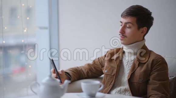 他坐在咖啡馆里自拍视频的预览图