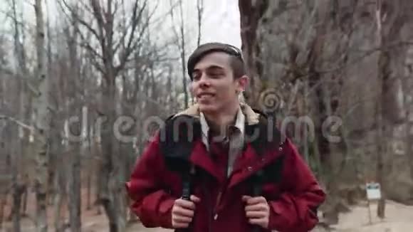 粗心的年轻迷人的游客带着背包在秋天的森林里游荡大冒险男性肖像视频的预览图