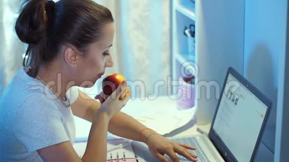 女人在笔记本电脑工作时吃东西视频的预览图